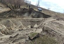 Двое мужчин экскаватором раскопали прибрежную зону, чтобы вытащить баржу из Иссык-Куля