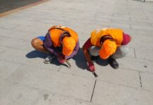 Сүрөт: «Тазалык» ишканасынын кызматкерлери борбордук аянттагы жабышкан сагыздарды кол менен тазалап жатышат