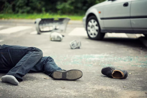 Person without shoe hit by a car on the road